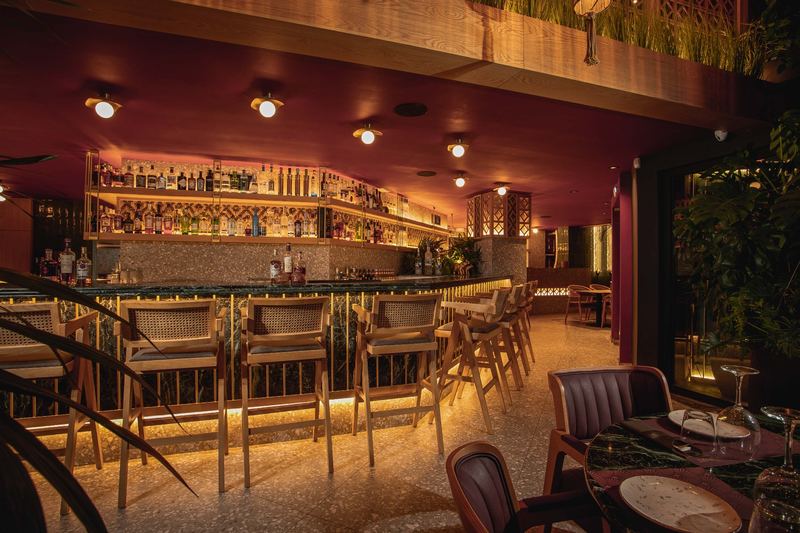 Al Hayat bar counter with backlit bottle shelves and gold-tone pendant lights