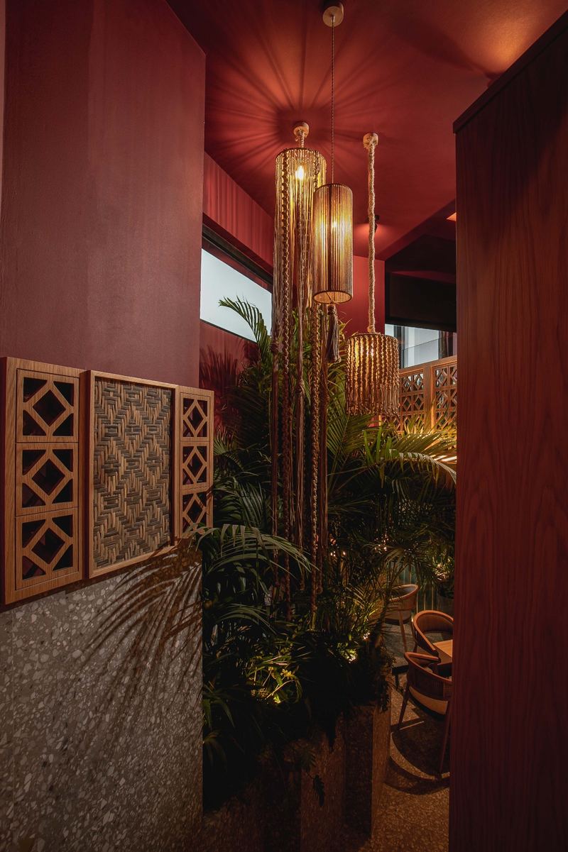 Cozy corner with hanging brass lamps casting warm gold light on velvet seating