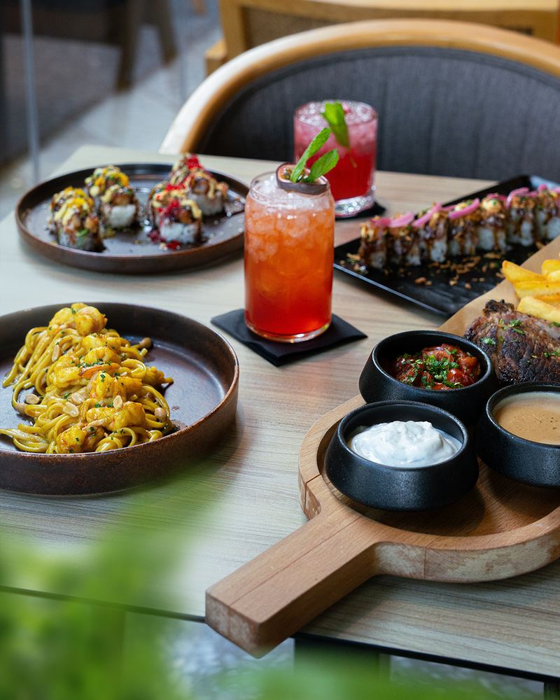 Family-style spread of Mediterranean fusion mezze, salads and mains on a wooden table