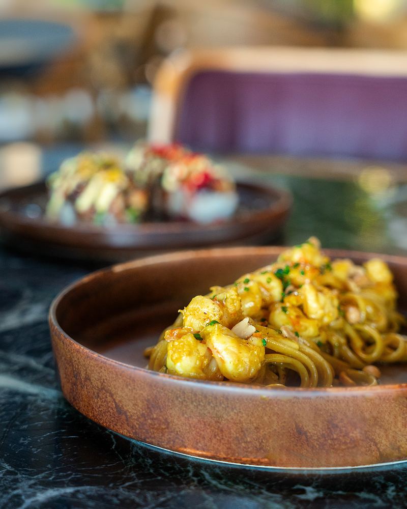 Prawn linguine pasta plated with fresh herbs and lemon