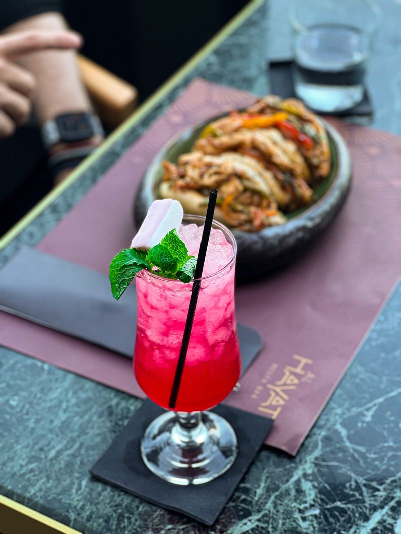 Pink berry cocktail garnished with fresh mint in a coupe glass