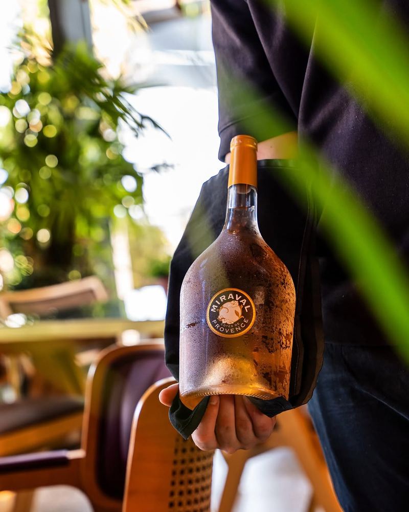 Chilled magnum of Miraval Côtes de Provence rosé wine, beaded with condensation, carried through Al Hayat's sunlit terrace
